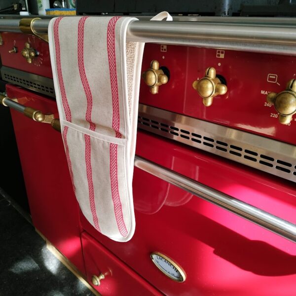 red striped double oven gloves hanging in front of a Lancanche red cooker
